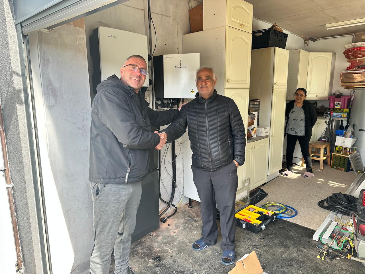 RenewAGen installer with a happy customer beside their new solar battery and inverter